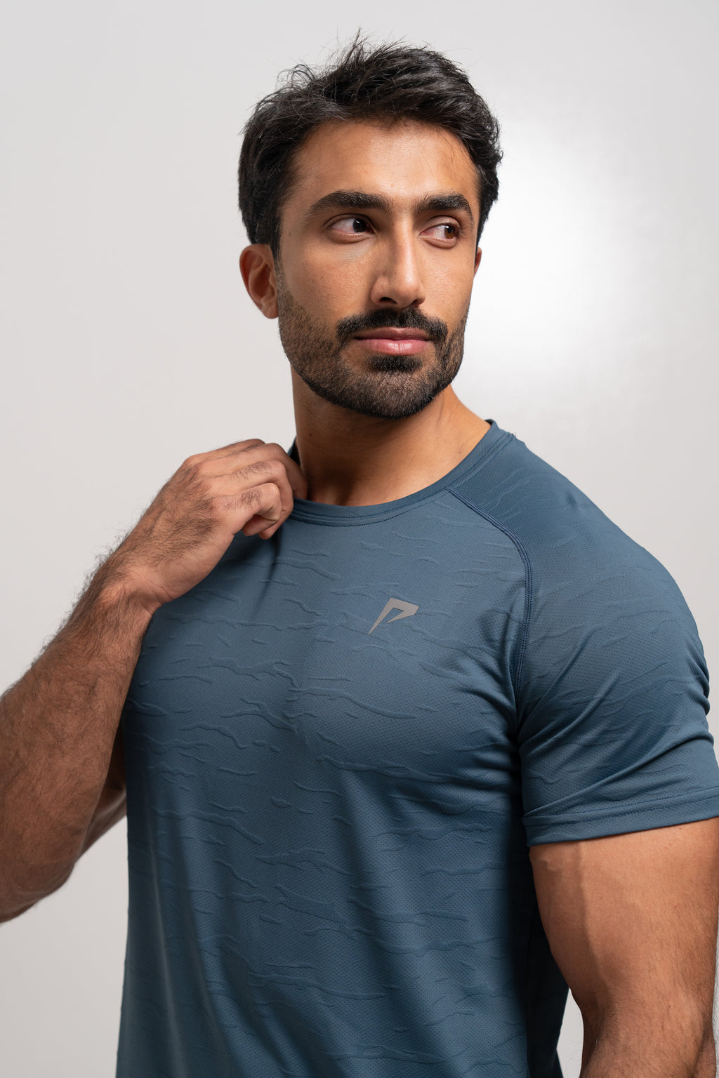 Man wearing a blue athletic shirt with a logo